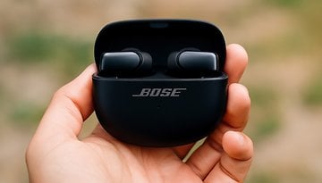Bose Ultra Open Earbuds in einer Hand, mit leicht geöffnetem Case und sichtbarem Bose-Logo.