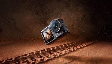 Eine DJI Action 4 Kamera schwebt über einer sandigen Oberfläche mit Reifenabdrücken.