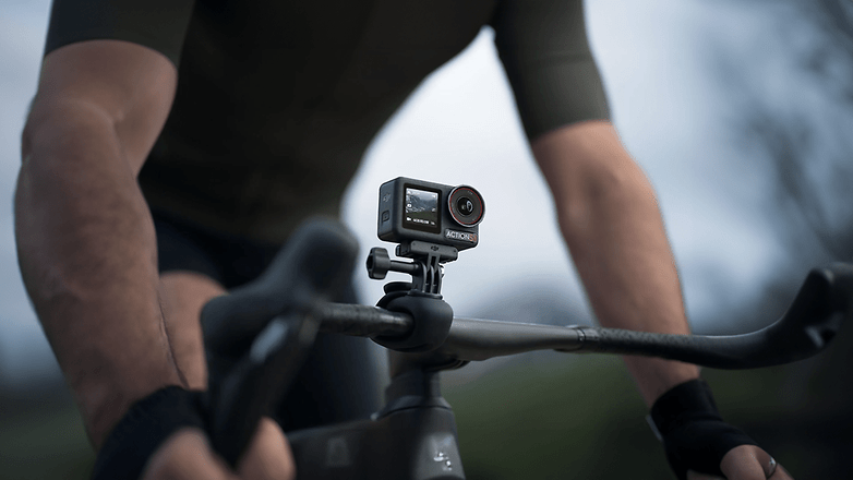 Ein Radfahrer greift die Lenkstange mit einer DJI Osmo Action 5 Pro Kamera, die am Fahrrad montiert ist.