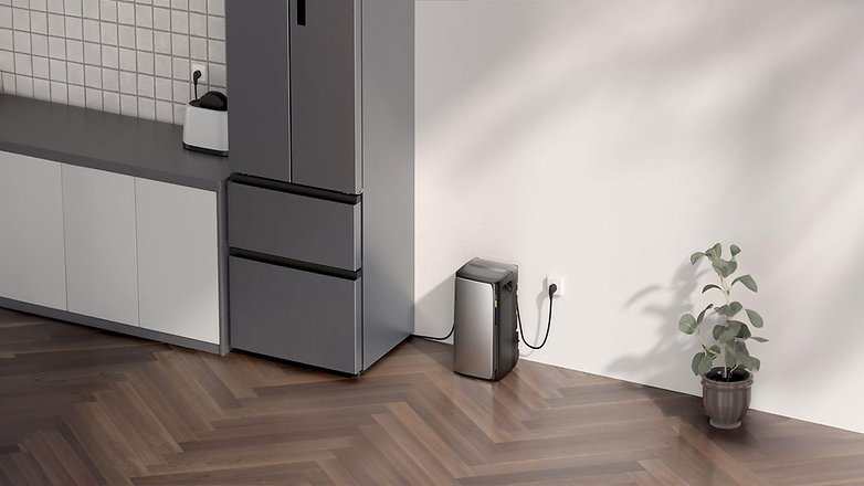 Ein schlankes EcoFlow Stream Ultra-Gerät neben einem grauen Kühlschrank und einer Topfpflanze in einem modernen Innenraum. Ein schlankes EcoFlow Stream Ultra-Gerät neben einem grauen Kühlschrank und einer Topfpflanze in einem modernen Innenraum.