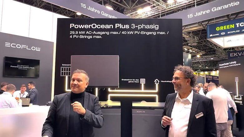 Zwei Männer präsentieren die Solar-Lösung PowerOcean Plus von EcoFlow auf einer Messe, mit angezeigten Spezifikationen.