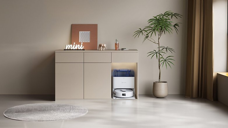 Ein moderner Wohnraum mit einem Ecovacs Deebot Mini Saugroboter neben einer Pflanze und Dekorationsartikeln. Ein moderner Wohnraum mit einem Ecovacs Deebot Mini Saugroboter neben einer Pflanze und Dekorationsartikeln.