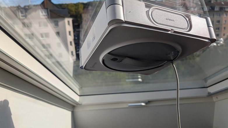 Ein Fensterputzroboter, Ecovacs Winbot W2S Omni, der an einem Fenster befestigt ist. Ein Fensterputzroboter, Ecovacs Winbot W2S Omni, der an einem Fenster befestigt ist.