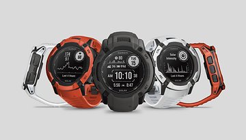 Drei Garmin Instinct 2X Solar-Uhren in Orange, Schwarz und Weiß, die Fitnessmetriken anzeigen.