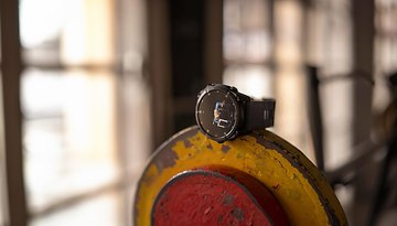 Eine Garmin Fenix 8-Uhr liegt auf einer Gewichtsscheibe in einem Fitnessstudio.