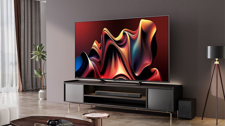 Ein Hisense HS2100 Fernseher, der abstrakte bunte Kunst zeigt, montiert an einem modernen Wandregal in einem stilvollen Wohnzimmer. Ein Hisense HS2100 Fernseher, der abstrakte bunte Kunst zeigt, montiert an einem modernen Wandregal in einem stilvollen Wohnzimmer.