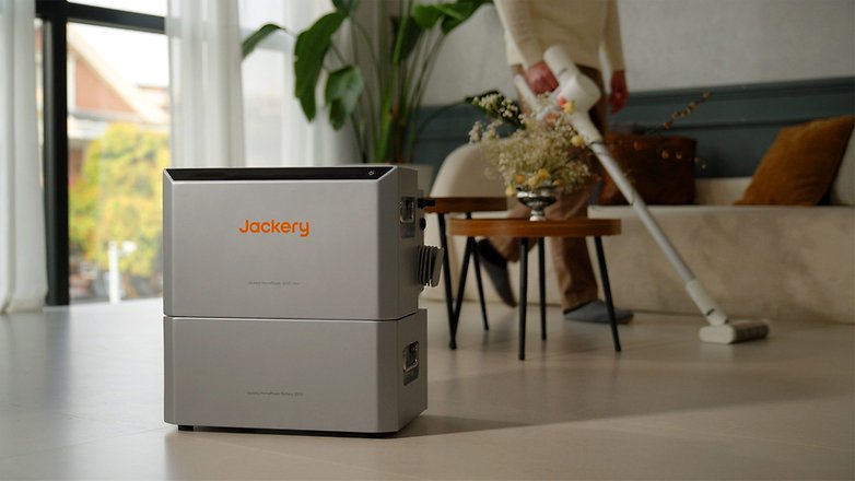 Jackery Home Power 2000 Ultra tragbare Powerstation in einem Wohnzimmer mit einer Person, die staubsaugt. Jackery Home Power 2000 Ultra tragbare Powerstation in einem Wohnzimmer mit einer Person, die staubsaugt.