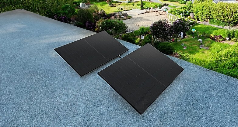 Zwei Solarpanels auf einem Dach mit Blick auf einen Garten.