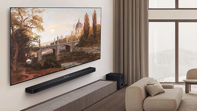 Ein modernes Wohnzimmer mit einem LG OLED B5 Smart-TV, der Kunst zeigt, mit einem Sofa und einer Soundbar.