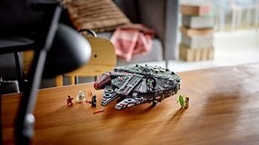 Ein LEGO Dark Millennium Falcon Modell mit Mini-Figuren auf einem Holztisch.