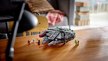 Ein LEGO Dark Millennium Falcon Modell mit Mini-Figuren auf einem Holztisch.