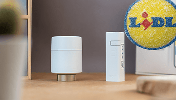 Tado Smart-Thermostat und Ventil auf einer Holzoberfläche mit Lidl-Logo in der Ecke.