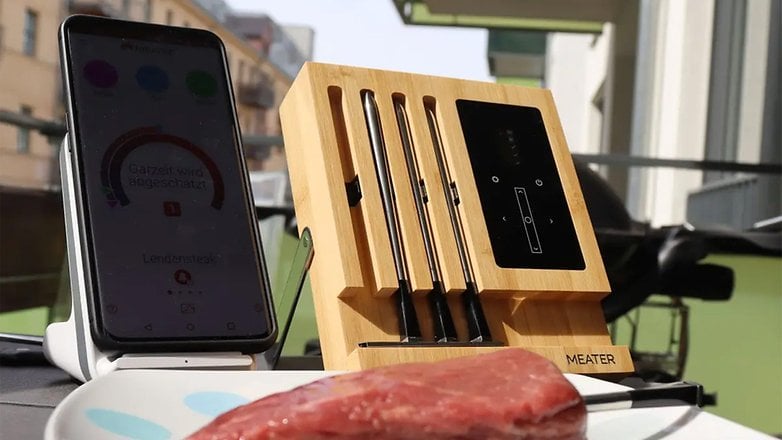 Meater smart thermometer next to a raw meat cut