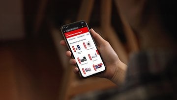 Eine Person hält ein Smartphone, das die Webseite des MediaMarkt-Gutscheinhefts zeigt.