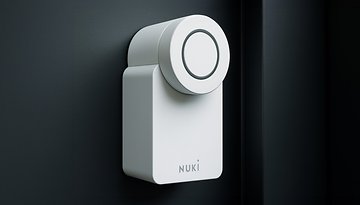 Ein Nuki Smart Lock an einer Tür, das ein elegantes weißes Design zeigt.