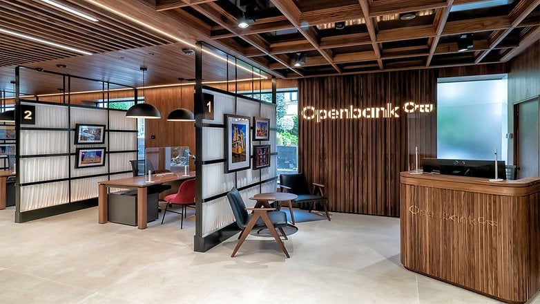 Moderne Bankinterieur mit Holzdekoration, Openbank-Schild und einzelnen Arbeitsplätzen. Moderne Bankinterieur mit Holzdekoration, Openbank-Schild und einzelnen Arbeitsplätzen.
