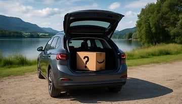Ein Auto, das am See geparkt ist, mit einem offenen Kofferraum, der eine Amazon-Box enthält.