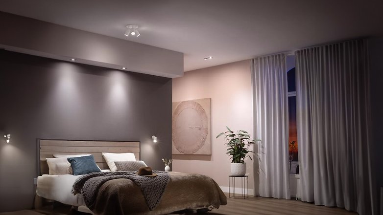Ein modernes Schlafzimmer mit einem Bett, Kunstwerk, Topfpflanze und Philips Hue GU10 Beleuchtung. Ein modernes Schlafzimmer mit einem Bett, Kunstwerk, Topfpflanze und Philips Hue GU10 Beleuchtung.