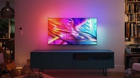 Ein Philips-Fernseher mit lebendigen Farben, an einer Wand über einem modernen TV-Schränkchen in einem gemütlichen Wohnzimmer.