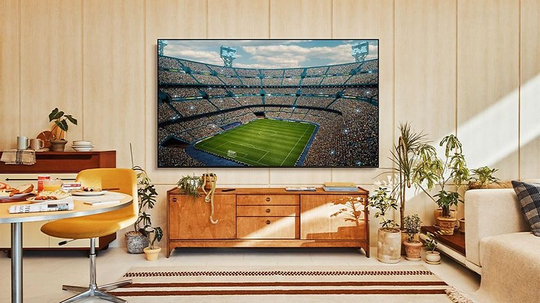 Ein Samsung Smart TV zeigt ein Fußballspiel in einem Wohnzimmer. Ein Samsung Smart TV zeigt ein Fußballspiel in einem Wohnzimmer.