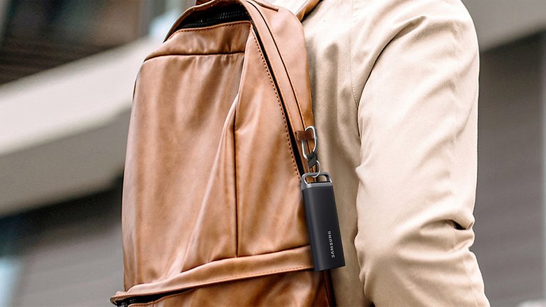 Ein Samsung T5 EVO SSD ist an einem braunen Rucksackgurt befestigt. Ein Samsung T5 EVO SSD ist an einem braunen Rucksackgurt befestigt.