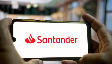 Ein Smartphone zeigt das Santander-Logo vor einem unscharfen Hintergrund.