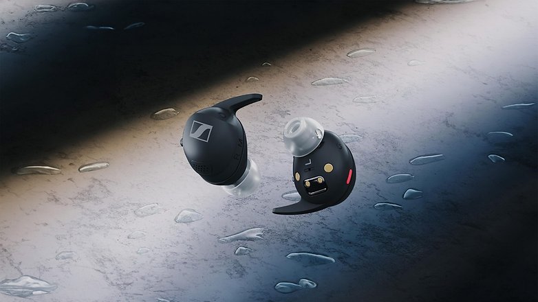 Schwarze Sennheiser Momentum Sport In-Ear-Bluetooth-Kopfhörer auf einer nassen Oberfläche. Schwarze Sennheiser Momentum Sport In-Ear-Bluetooth-Kopfhörer auf einer nassen Oberfläche.