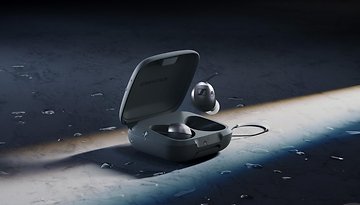 Sennheiser Momentum Sport In-Ear-Kopfhörer in Ladecase auf einer nassen Oberfläche.