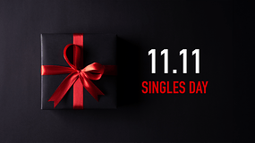 Ein schwarzes Geschenk mit rotem Band auf dunklem Hintergrund, mit dem Text '11.11 SINGLES DAY'.