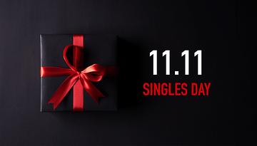 Ein schwarzes Geschenk mit rotem Band auf dunklem Hintergrund, mit dem Text '11.11 SINGLES DAY'.