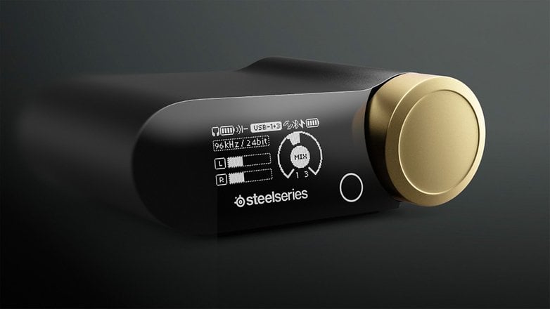 SteelSeries Arctis Nova Elite Gaming-Headset-Controller mit goldener Taste und Anzeige für Audioeinstellungen.
