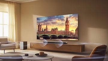 Ein modernes Wohnzimmer mit einer TCL-Soundbar unter einem großen Fernseher, der eine malerische Ansicht von Big Ben zeigt.