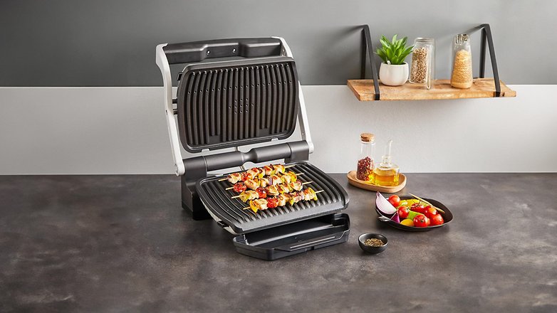 Tefal Optigrill+ mit Spießen und Gemüse auf dem Grill, auf einer Küchenarbeitsplatte platziert. Tefal Optigrill+ mit Spießen und Gemüse auf dem Grill, auf einer Küchenarbeitsplatte platziert.