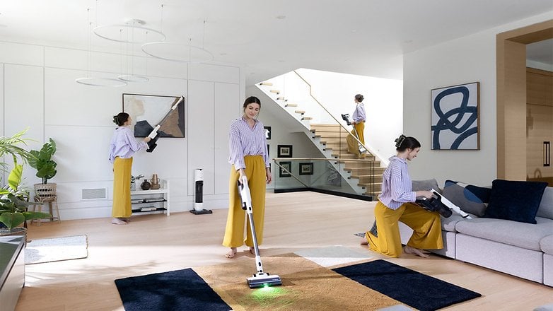 Eine Frau in einem gestreiften Hemd und gelben Hosen saugt ein modernes Wohnzimmer mit dem Tineco Pure One Station 5. Eine Frau in einem gestreiften Hemd und gelben Hosen saugt ein modernes Wohnzimmer mit dem Tineco Pure One Station 5.