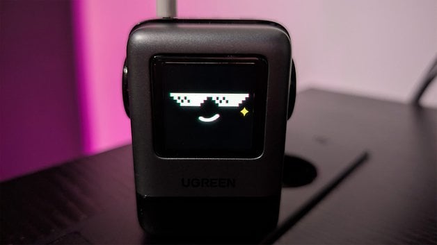 A Ugreen Uno 100W device shows a pixel art face with sunglasses and a smile.