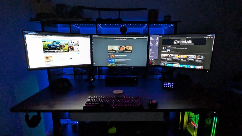 Ein Schreibtisch mit zwei Monitoren, die verschiedene Webseiten anzeigen, beleuchtet von blauen LED-Lichtern. Ein Schreibtisch mit zwei Monitoren, die verschiedene Webseiten anzeigen, beleuchtet von blauen LED-Lichtern.