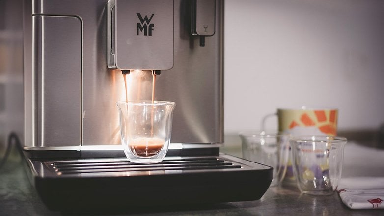 Eine WMF-Kaffeemaschine, die Espresso in eine Glasschale ausgießt, mit weiteren Tassen im Hintergrund.