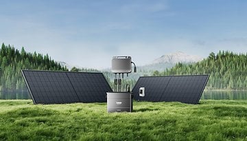 Solarmodule mit einem Solargenerator in einer grünen Landschaft am See und Bergen.