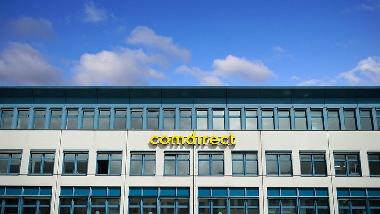 Gebäudefassade mit 'comdirect'-Schild vor blauem Himmel.