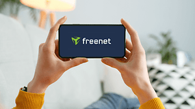 Eine Person hält ein Smartphone mit dem freenet-Logo.