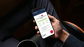 Eine Person hält ein Smartphone, das einen Telekom-Plan von freenet zeigt, preislich bei 11,99 €.