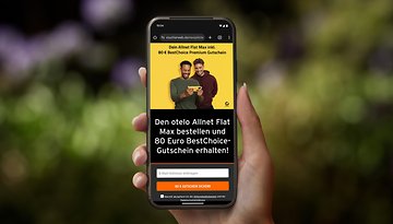 Eine Hand hält ein Smartphone, das eine Anzeige für den otelo Allnet Flat Max mit einem Gutschein über 80 € BestChoice zeigt.