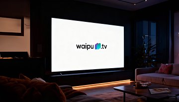 Ein modernes Wohnzimmer mit einem großen Fernseher, der das waipu.tv-Logo zeigt.