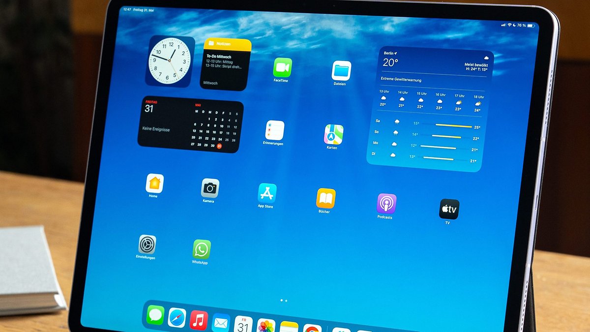A tablet screen displaying various apps including WhatsApp and a calendar.