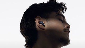 A young man with dark hair wearing Audio-Technica earbuds, side profile against a white background.