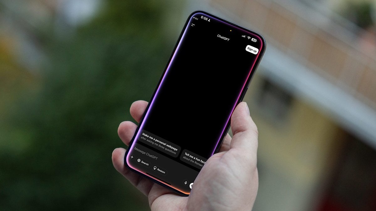 Une personne tenant un Apple iPhone 15 Pro Max avec un écran noir affichant une interface de chat.