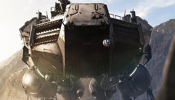 A large futuristic vehicle stands on a beach, surrounded by rocky terrain under a clear sky.