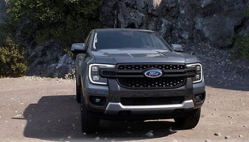 A gray Ford Ranger pickup truck parked on rocky terrain.