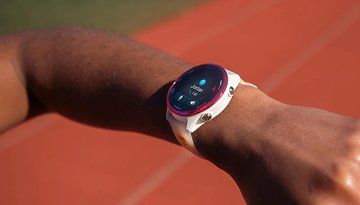 Um relógio Garmin Forerunner 570 no pulso de uma pessoa, exibindo uma tela com o nome 'Jordan' e estatísticas.