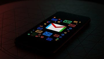 A smartphone displaying the Gmail logo on a colorful background with various email icons.